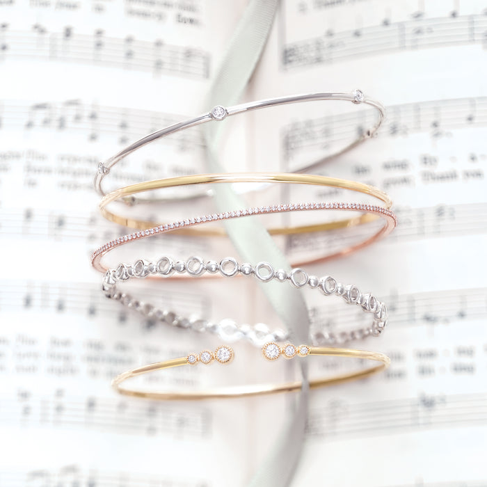 14K Gold and Diamond Bangle Bracelets Shown in a Stack