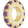 Gold charm with purple gemstones on a white background