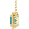 Gold pendant with a green gemstone on a white background