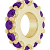 Gold charm with purple gemstones on a white background