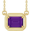 Gold necklace with a purple gemstone on a white background