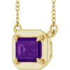 Gold necklace with a purple gemstone pendant on a white background