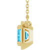 Gold pendant with a blue gemstone on a white background