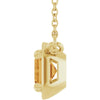 Gold pendant with a clear gemstone on a white background