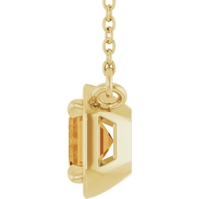 Gold pendant with a clear gemstone on a white background