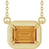 Gold pendant with a large orange gemstone on a white background