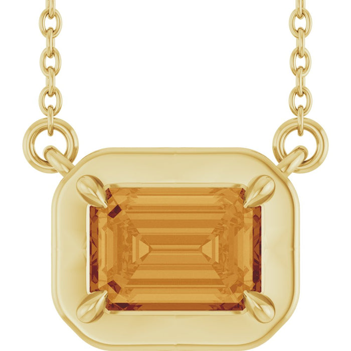Gold pendant with a large orange gemstone on a white background