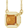 Gold necklace with a large orange gemstone on a white background