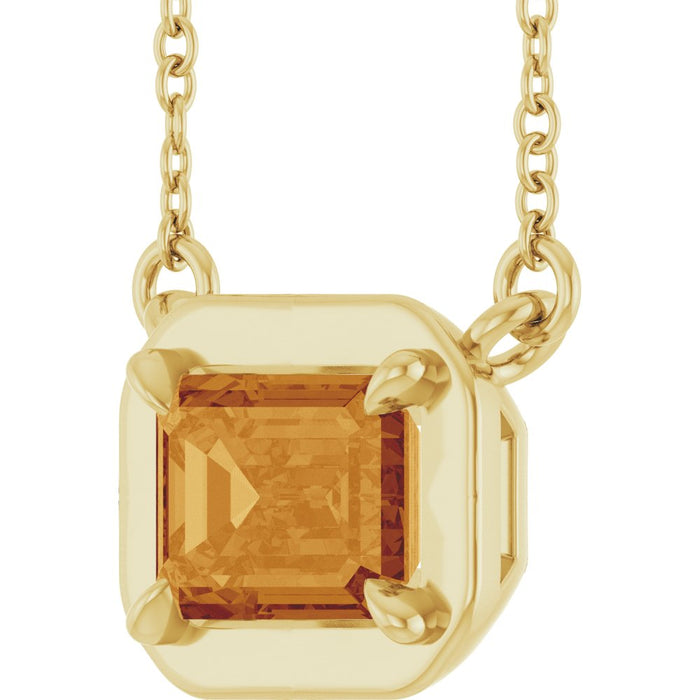 Gold necklace with a large orange gemstone on a white background