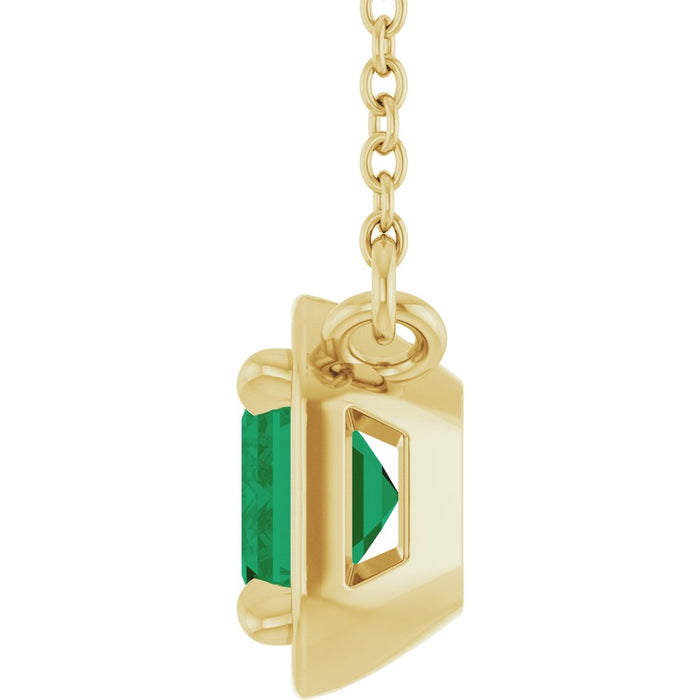 Gold pendant with a green gemstone on a white background