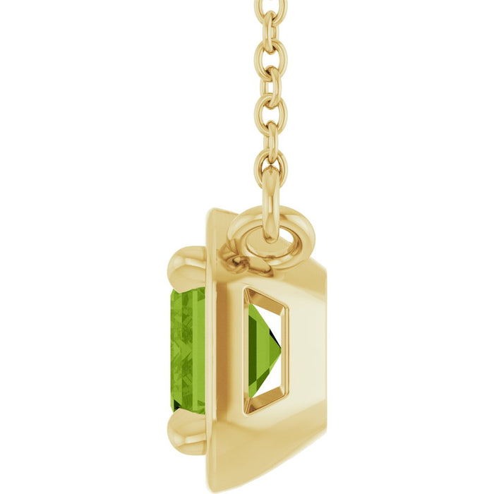 Gold pendant with a green gemstone on a white background