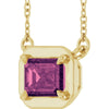 Gold necklace with a purple gemstone pendant on a white background