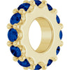 Gold charm with dark blue gemstones on a white background