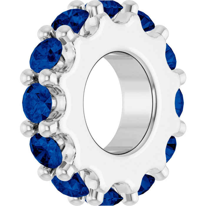 White gold charm with blue gemstones on a white background