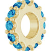 Gold charm with ocean blue gemstones on a white background