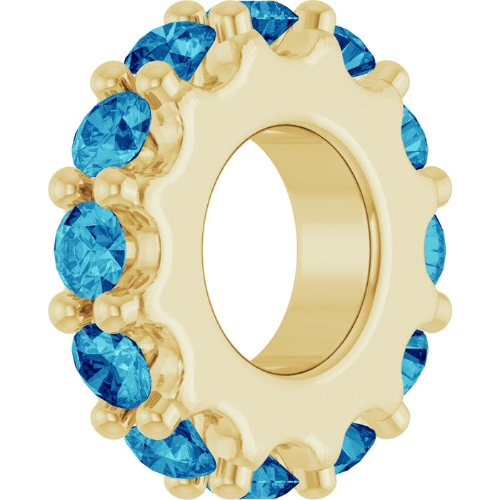 Gold charm with ocean blue gemstones on a white background