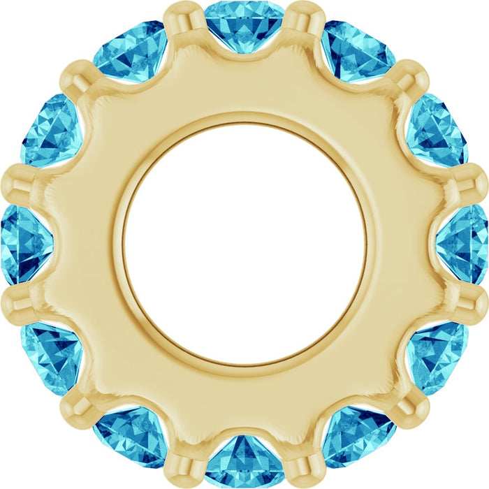 Gold charm with ocean blue gemstones on a white background