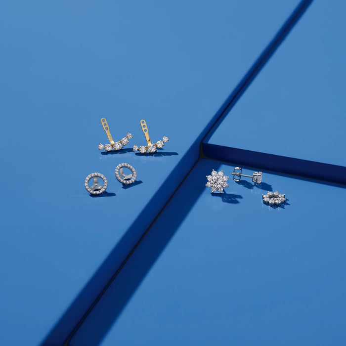 Various diamond earring jackets on blue background 