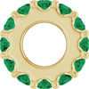 Gold charm with green gemstones on a white background