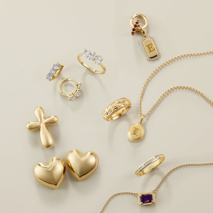 Collection of gold jewelry including rings, earrings, and necklaces on a beige background