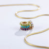 Gold necklace with colorful gemstone slider charms on a white background