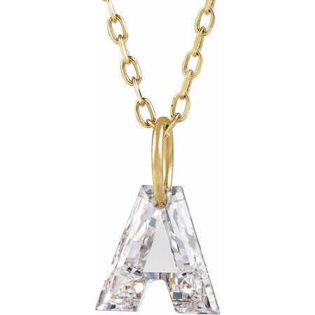 Gold necklace with a floating diamond a initial on a white background