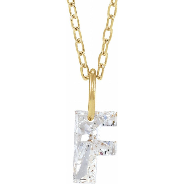 Gold necklace with a floating diamond f initial on a white background