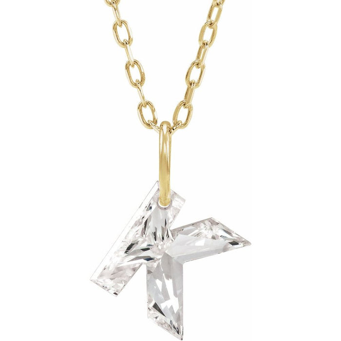 Gold necklace with a floating diamond k initial on a white background