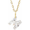 Gold necklace with a floating diamond m initial on a white background