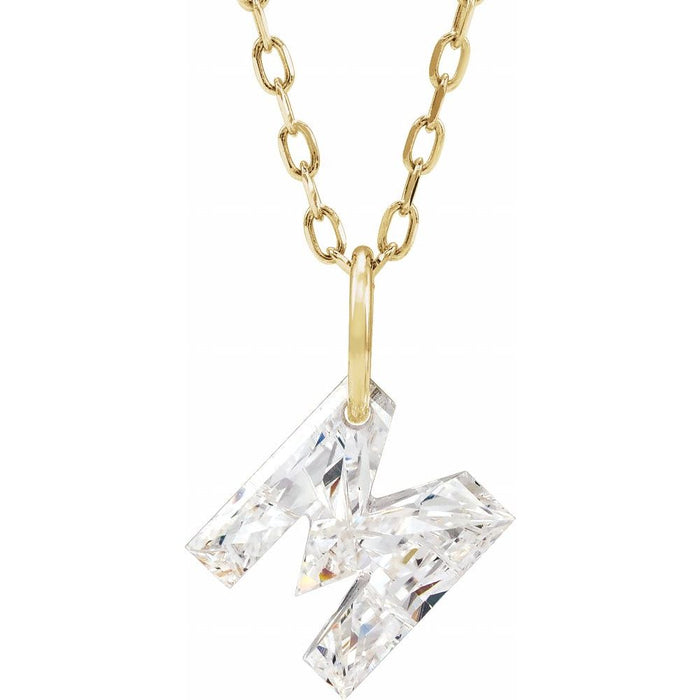 Gold necklace with a floating diamond m initial on a white background