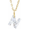 Gold necklace with a floating diamond n initial on a white background