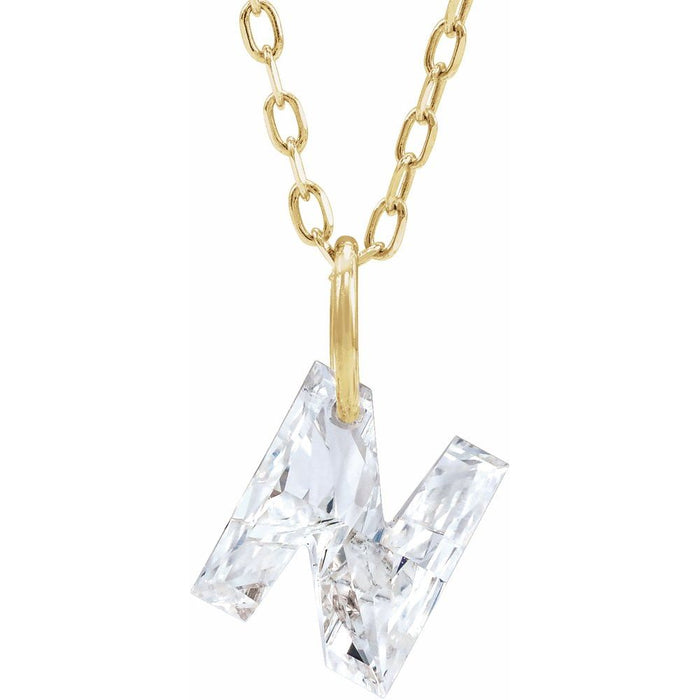 Gold necklace with a floating diamond n initial on a white background