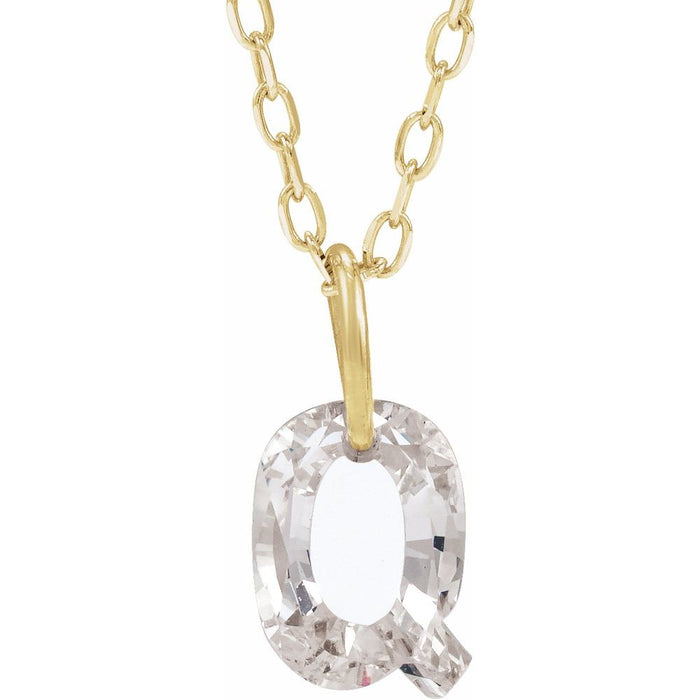 Gold necklace with a floating diamond q initial on a white background