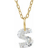 Gold necklace with a floating diamond s initial on a white background