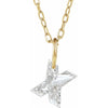 Gold necklace with a floating diamond x initial pendant on a white background