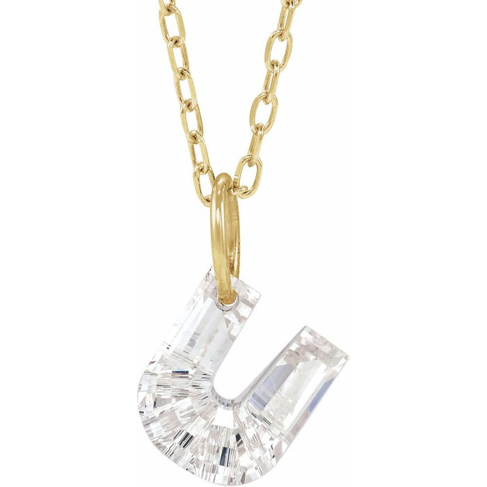 Gold necklace with a floating diamond u initial on a white background