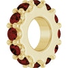 Gold charm with dark red gemstones on a white background