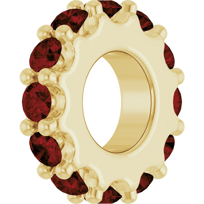 Gold charm with dark red gemstones on a white background