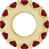 Gold charm with dark red gemstones on a white background