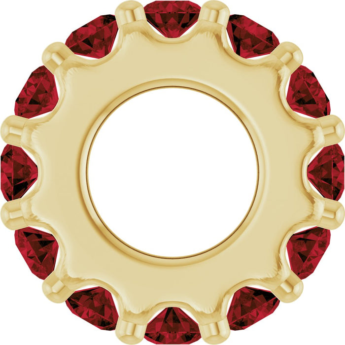 Gold charm with dark red gemstones on a white background