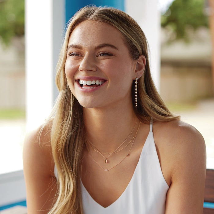 Model wearing drop dangle lab-grown diamond earrings
