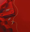 Bracelets, necklace with charms, gold script 'mama' ring on a red background