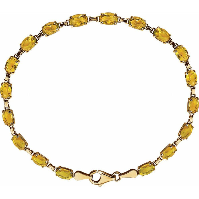 A yellow citrine gemstone tennis bracelet with oval faceted gemstones set in yellow gold, featuring a matching gold lobster clasp, shown on a plain white background.