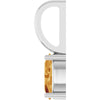 Close-up of a citrine gemstone set in white gold pendant on a white background