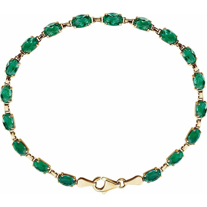 A gold-plated tennis bracelet featuring a row of oval-cut green emerald gemstones, displayed on a clean white background.