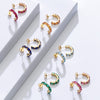 Colorful hoop earrings on a white surface