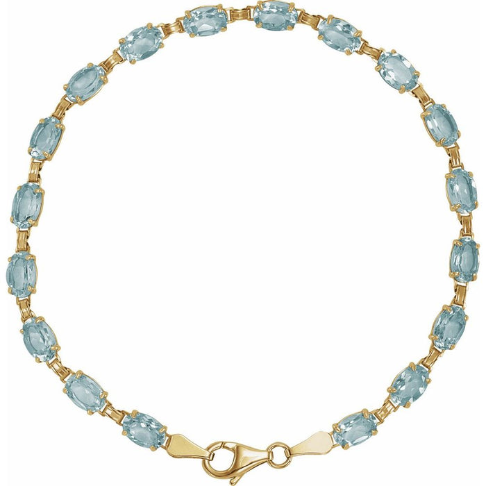A yellow gold tennis bracelet featuring a row of light blue oval cut sky blue topaz gemstones, displayed on a clean white background.