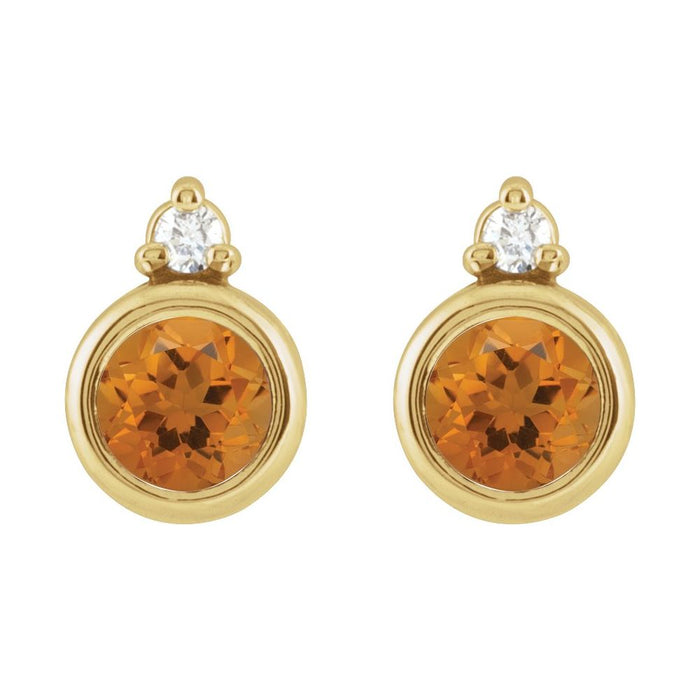 A pair of yellow gold stud earrings featuring a round faceted citrine gemstone in a bezel setting, with a  round diamond at the top, shown on a plain white background.