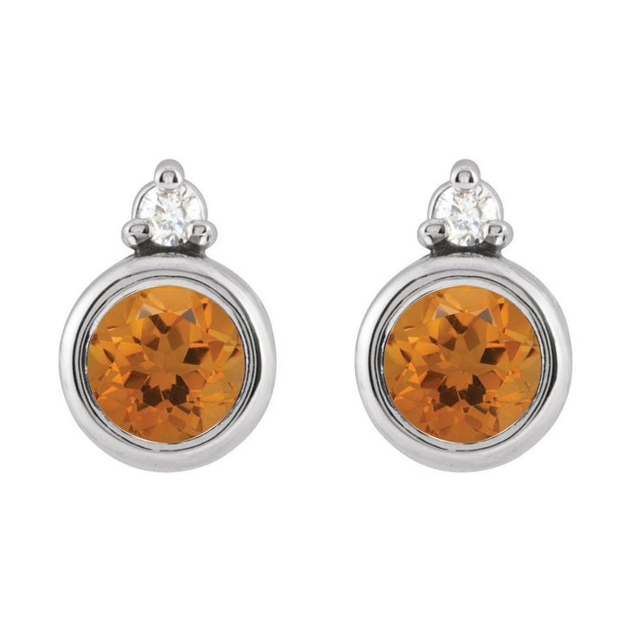 A pair of round stud earrings featuring faceted citrine gemstone in white gold bezel settings, with a diamond at the top, shown on a plain white background.