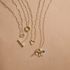 Gold charm necklaces with paperclip style links and different shaped charm bails.